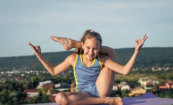 Gymnastiek en yoga meditatie. gelukkig tiener meisje op lucht achtergrond. Het kind heeft een flexibel lichaam. kind in sport kleding training. Uitrekken en opwarmen. Kindergeluk. gezondheid en fitness — Stockfoto