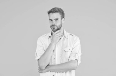 Tüylü ciddi bir adam kot pantolon giyer, sarı arka plan, yüz bakımı