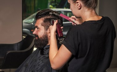 Usta Barber saç stilini ve saç stilini elektrikli traş makinesiyle yapıyor.