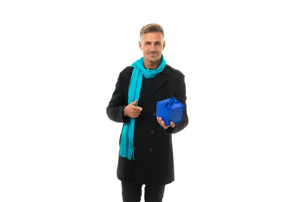Hombre guapo feliz en abrigo con la bufanda larga señalando el dedo en la caja actual, regalo — Foto de Stock