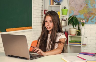 Öğrenci çocuk okulda okuyor. İşyeri sınıfında, öğreniyor.