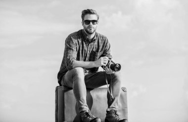 Video bloğu çekiliyor. Tatil zamanı. Seyahat blogu. Adam bavula oturur. Yakışıklı gezgin geçmişe dönük kamera. Klasik valizli bir adam. Fotomuhabir konsepti. Bagajla seyahat et. Seyahat blogçusu