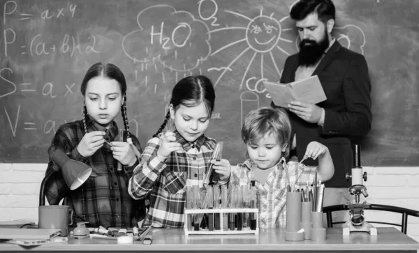 Εργαστήριο Χημείας. Πίσω στο σχολείο. Χαρούμενα παιδιά και δάσκαλος. παιδιά με εργαστηριακή ποδιά μαθαίνουν χημεία στο σχολικό εργαστήριο. πειραματισμός σε εργαστηριακό ή χημικό ντουλάπι. Φάρμακα που μπορείς να εμπιστευτείς — Φωτογραφία Αρχείου