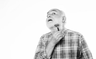 Beyaz sakallı, olgun bir adam. Kes ve saç fırçala. Berber dükkanı konsepti. Traş aksesuarları. Tıraşsız yaşlı adamın bıyığı ve sakalı var. Tıraş bıçağı alet çantası. Boşluğu kopyala