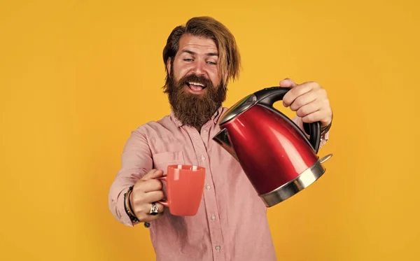 this is for you. bearded man use red electric kettle. male housekeeping concept. need some hot water. man going to drink tea or coffee. brutal man with moustache and beard. electric home device