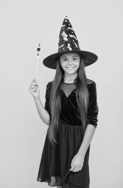 Gerçek bir büyücü. Çocuk sihirli değneği tutuyor. Büyücülük ve büyücülük. çocukluk sonbahar tatili. Genç kız kutlamaya hazır. Kostüm partisi eğlencesi. Cadılar bayramın kutlu olsun. Cadı şapkalı gülümseyen çocuk