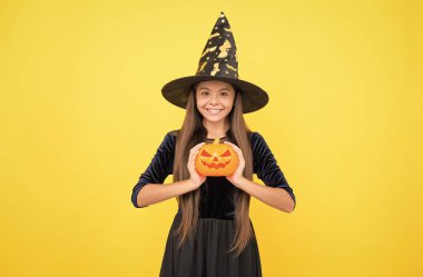 Korkutmak için fazla sevimli. Şeker mi şaka mı? Bayramları kutlarız. Balkabağı feneri. Cadılar Bayramı cadısı kız. Mutlu çocukluk. Cadı şapkalı ergen çocuk. Neşeli çocuk balkabağı tutuyor. Karnaval kostüm partisi