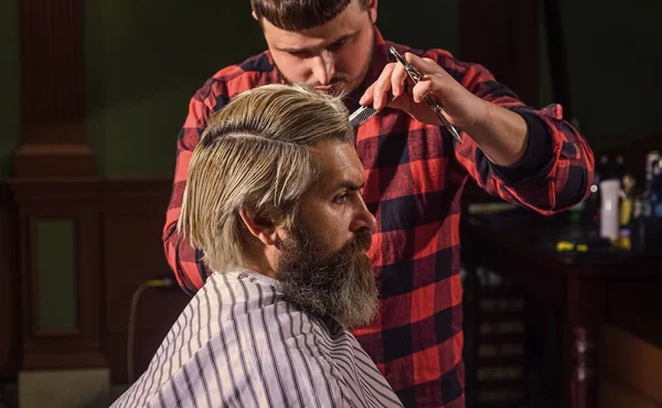 Um cliente Hipster a cortar o cabelo. Tesoura de barbeiro. Gerencie suas expectativas. Cortar cabelo. Barbeiro fazendo penteado para barbearia homem barbudo fundo. Cara com longos cabelos loiros tingidos fechar a vista traseira — Fotografia de Stock