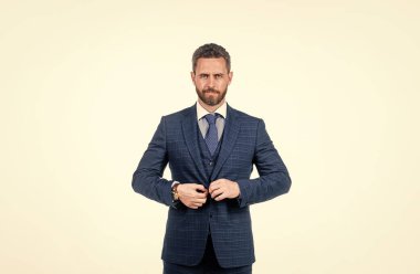 Beyaz tenli yakışıklı adam. Kendine güvenen erkek patron ceketini ilikliyor..