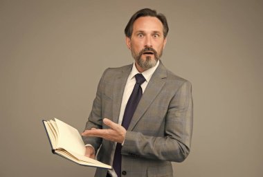 Resmi takım elbiseli son sınıf öğretmeni şaşırmış görünüyor. Gri bir geçmişi var, öğretmenlik yapıyor.