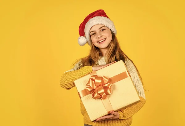 Kislány Mikulás sárga háttérrel. Karácsonyi ünnepség. Boldog új évet! Karácsonyi vásárlás online. Itt az ideje a kedvezménynek. Mosolygó gyerek megtartja vásárlás. ajándékok és ajándékok a Mikulástól — Stock Fotó