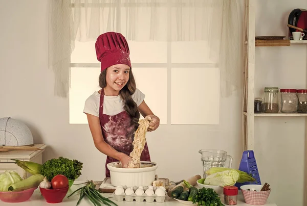 Ontwikkeling van kinderen. klein meisje bakken in de keuken. Knappe kok die deeg maakt. kind bereiden gezonde voeding thuis en het dragen van kok uniform. Huishouding en hulp aan huis. Calorie en dieet — Stockfoto