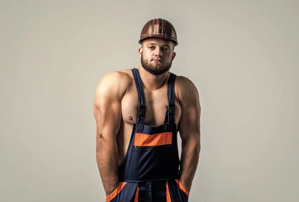 강한 몸을 가진 근육질의 건축가. 노동자 제복을 입고 있는 남자. 헬멧을 쓴 운동 선수. 몸 근육 이 있는 섹시 한 남자. 전문적 인 건설자 나 정비공. 건축 기사 — 스톡 사진