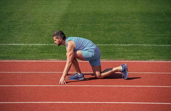 Corredor pronto para ir. O atleta se prepara para correr no estádio. Dicas de corrida para iniciantes. — Fotografia de Stock