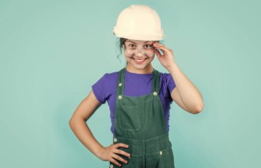 Ustabaşı ergen çocuk. Çocuk kaskla çalışıyor. Kasklı küçük kız. Tamir yapan bir kız. Başlık takmış bir genç. Çocukluk gelişimi kavramı. Kasklı kız inşaat işçisi.