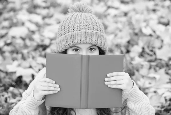 Il n'y a pas de compagnon plus ferme que le livre. Petit visage de couverture d'enfant avec livre feuilles d'automne. Journée du savoir. Bibliothèque scolaire. Enseignement de la lecture. Cours de littérature. Imagination et fantaisie — Photo