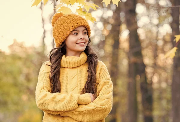 Chica en suéter y sombrero de punto amarillo. niño disfrutar de la naturaleza en el parque de otoño. el otoño es un tiempo para la diversión. moda de otoño para los niños. estilo otoño de niño. los géneros de punto le calientan en cualquier tiempo —  Fotos de Stock