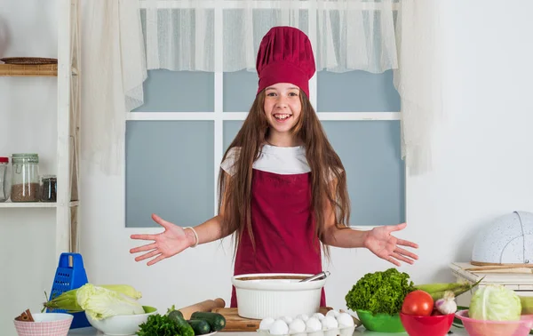 요리용 유니폼을 입은 십 대 소녀 가 부엌에서 음식을 준비 한다. — 스톡 사진