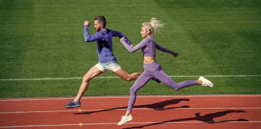 Aşırı antrenman. Spor çifti kazanmak için hızlı koşar. Başarılı fitness koşucuları. Atletik erkek ve seksi kadın sprint 'te yarışıyorlar. Erkek ve kadın stadyumda koşu pistinde. Sağlıklı bir yaşam tarzı. maraton hızı