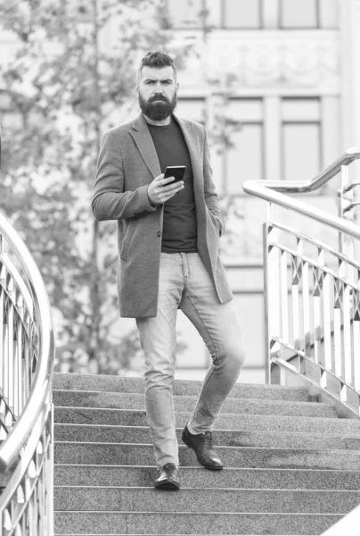 Busy hipster in casual business style walk down stairs holding mobile phone urban outdoors, man — Stock Photo, Image