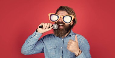 Harika bir ses. Parti gözlüklü vahşi beyaz hippi. Karaoke şarkıcısı. Tıraşsız, uzun saçlı adam. Berber ve kuaför. Erkek mikrofonda şarkı söyler. Mikrofonlu komik sakallı adam.