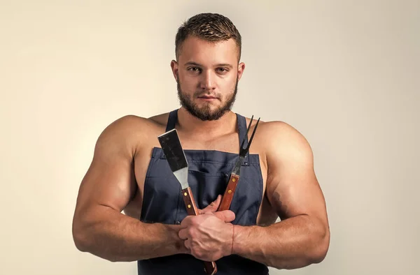 배고파요. 요리 앞치마에 bbq 도구를 단 섹시 한 남자. 전문적 인 미남 요리사 요리. 요리와 요리. 근육질의 남자는 바베큐 기구를 사용 합니다. 건강 한 식사를 하는 것입니다. 운동 선수들을 위한 식품 — 스톡 사진