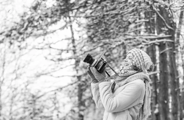 在冬天的森林里拍照。摄影师在雪天拍照.快乐的女人穿暖和的衣服。寒假。时髦的嬉皮士旅行者。拿着照相相机的女人 — 图库照片