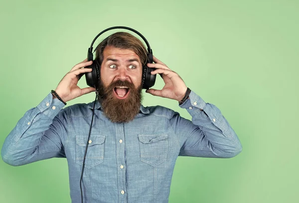 Een man met een baard en een koptelefoon. Luister naar muziek. concept van online onderwijs. audioboek. Luister naar mijn favoriete liedje. nieuwe technologie in het moderne leven. digitaal leven. hipster in headset — Stockfoto