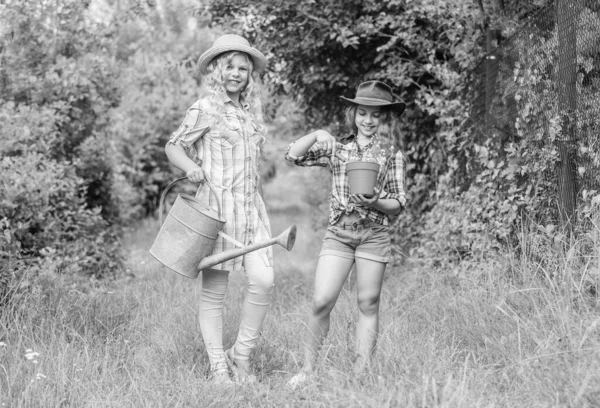 Enfants rustiques arrière-plan nature. Concept d'agriculture. Les filles dans des chapeaux plantant des plantes. Des sœurs qui aident à la ferme. Ferme familiale. Les enfants s'amusent à la ferme. Concept d'éco-agriculture. Plantation et arrosage — Photo