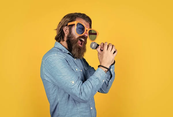 Holen Sie sich einen hohen Ton. Brutaler männlicher Hipster mit Mikrofon. Gesangsschule. Lieblingsmusik. Konzept der Musik. Darsteller, die Spaß haben. Älterer bärtiger Mann in lustiger Partybrille singt Lied — Stockfoto