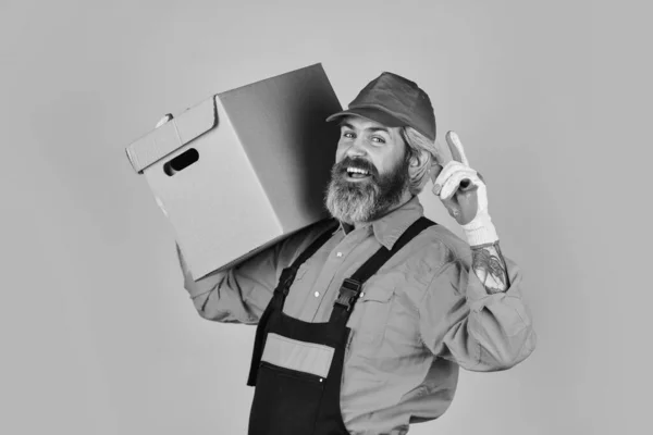 Es ist immer Samstag. Umzugskartons auspacken. Neues Haus am Umzugstag. Man builder in boilersuit hold boxes. Umzug in eine neue Wohnung. Glücklicher Mann Karton. Kisten im Gebäude tragen — Stockfoto