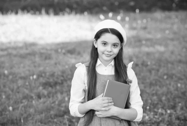 Elegante colegiala niña con libro en el parque, concepto de colegiala sofisticada —  Fotos de Stock