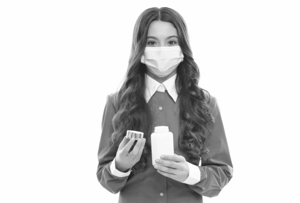 Дівчина тримає вітаміни або таблетки від лихоманки в захисній медичній масці ізольовані на білому, вірус корони — стокове фото