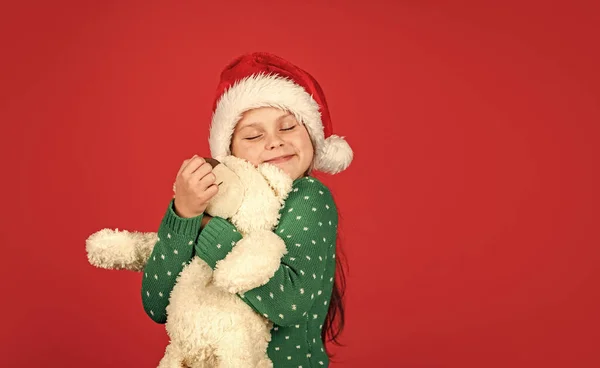 Osito de peluche. Vibras navideñas. Oso polar. Comprando regalos de Navidad. Vacaciones de Navidad. Temporada alegre de invierno. Venta de compras de Navidad. Pequeño Santa con juguete. Niña santa claus sombrero rojo fondo —  Fotos de Stock