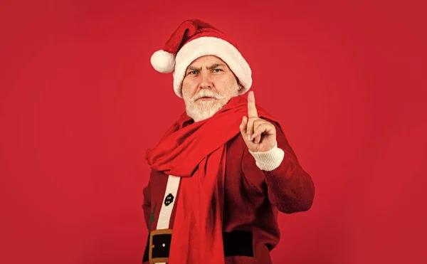 Komoly végzős Télapó jelmezben. Boldog új 2021-es évet. Boldog karácsonyt! szakállas télapó sálban, vörös háttérrel. Karácsonyi ajándékok és ajándékvásárlás. téli nyaralás öröm — Stock Fotó