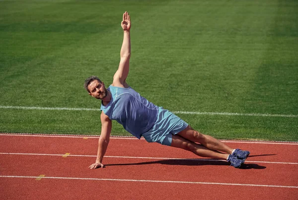 Homem muscular ficar na prancha lateral alongamento no treinamento esportivo, ioga — Fotografia de Stock