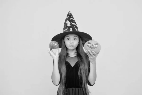 子供は不気味なカボチャを保持します。魔術と魔法だ。子供の秋の休日。お祝いの準備ができて10代の女の子。コスチュームパーティーの楽しみ。ジャック・オ・ランタン。ハッピーハロウィーン。魔女の帽子の面白い子 — ストック写真
