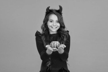 Doğal bir yetenek. Neşeli çocuk balkabağı taşıyor. Jack O Feneri yapmak. Karnaval kostüm partisi. Şeker mi şaka mı? Bayramları kutlarız. çocukluk. Mutlu cadılar bayramı şeytan kızı. Boynuzlu ergen çocuk