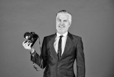 Genç uzmanlar. Klasik kamera. Mutlu iş adamı retro kamerayı tutar. Olgun bir adam sakal ve saç boyadı. Profesyonel fotoğrafçı fotoğraf çeker. Erkek güzeli. Berber salonunun yakalama sonuçları