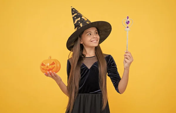 Criança bruxa feliz com varinha mágica e macaco de abóbora o lanterna usar traje de feiticeiro na festa de Halloween, jogo milagre halloween — Fotografia de Stock