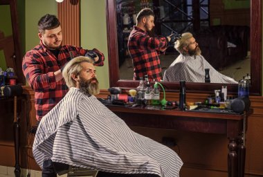 Hippi saç tıraşı oluyor. Saçları boyalı bir adam. Berber berber dükkanı. Berber kozmetik. Kuaför aletleri. Berber işlemler üzerinde yoğunlaşmıştı. Saç şekillendiriyorum. İşlemleri değiştirmek neredeyse imkansız.