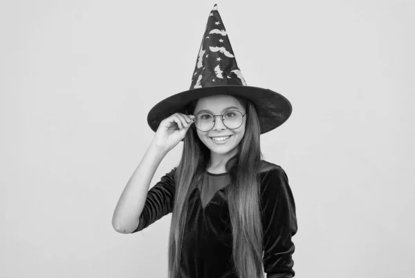 Halloween tini lány boszorkány kalap és szemüveg néz ki, mint a varázsló iskolai tanuló, boldog halloween — Stock Fotó
