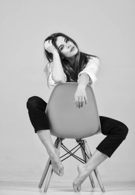 Uzun saçlı, oyuncu bir model. Evde saç nasıl düzeltilir. Yaz makyajı. Kız sandalyeye oturur. Doğal makyajlı bir kız. Kuaför salonu. Kadın şehvetli görünümü. Moda mankeni sıradan görünüyor. Evde kal.