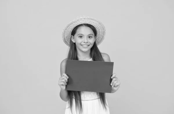 Χαρούμενο μοντέλο μόδας. Το κοριτσάκι κρατάει χαρτί. μόδα στην παραλία για παιδιά. μικρό παιδί σε κίτρινο φόντο. καλοκαιρινή κατασκήνωση. αντίγραφο χώρου. καλοκαιρινές διακοπές και διακοπές. Χαρούμενη παιδική ηλικία — Φωτογραφία Αρχείου