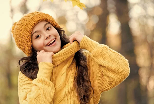 Friss levegő és jó hangulat. Őszi divat gyerekeknek. Őszi gyermekstílus. A kötöttáru melegít minden időben. Egy lány kötött pulóverben és kalapban. A gyerek élvezi a természetet az őszi parkban. Az ősz a szórakozás ideje. — Stock Fotó