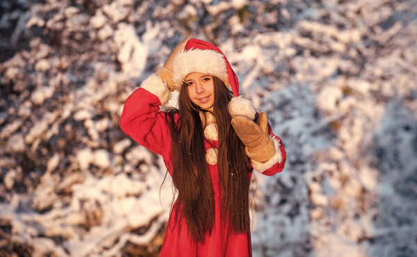 spend winter holiday with joy. santa claus helper. little girl enjoy season. small girl in santa costume play with snow. snowy winter nature. happy new year. child in warm mittens