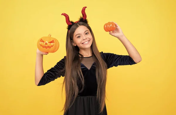 Feliz bruja adolescente diablo chica usar imp cuernos traje en halloween fiesta y mantener calabaza jack o linterna, fiesta de halloween diversión — Foto de Stock