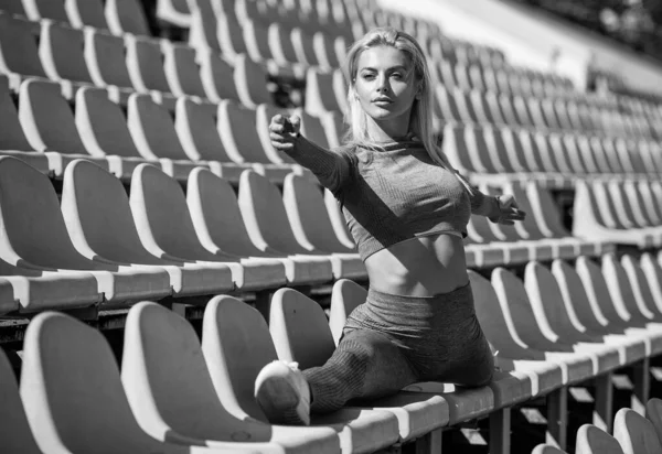 Atletyczna kobieta w stroju fitness siedzieć w split na stadionie, split — Zdjęcie stockowe