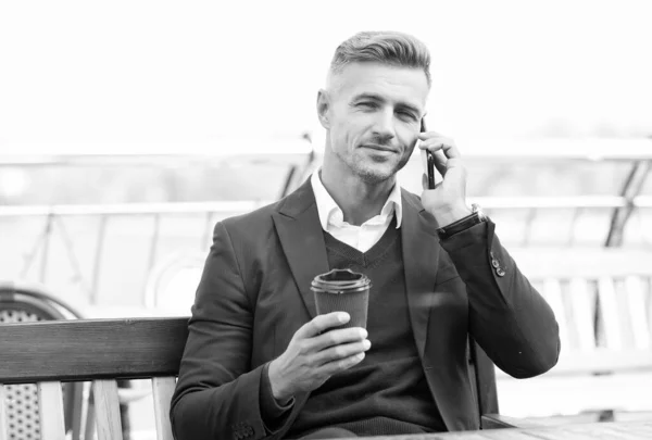 Bir fincan kahve içerken iş konuşuyoruz. Yakışıklı adam telefon görüşmesi yapıyor. İş iletişimi. Gezici konuşma. Kahve molası. Modern hayat. Yeni teknoloji — Stok fotoğraf