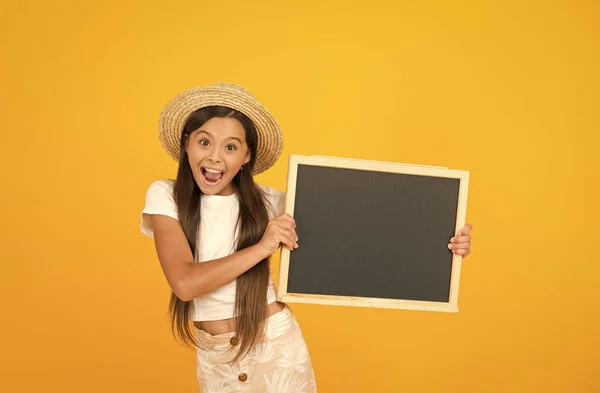 Liten flicka barn bära sommar stil hatt hålla tavlan information kopiera utrymme, spännande reklam koncept — Stockfoto